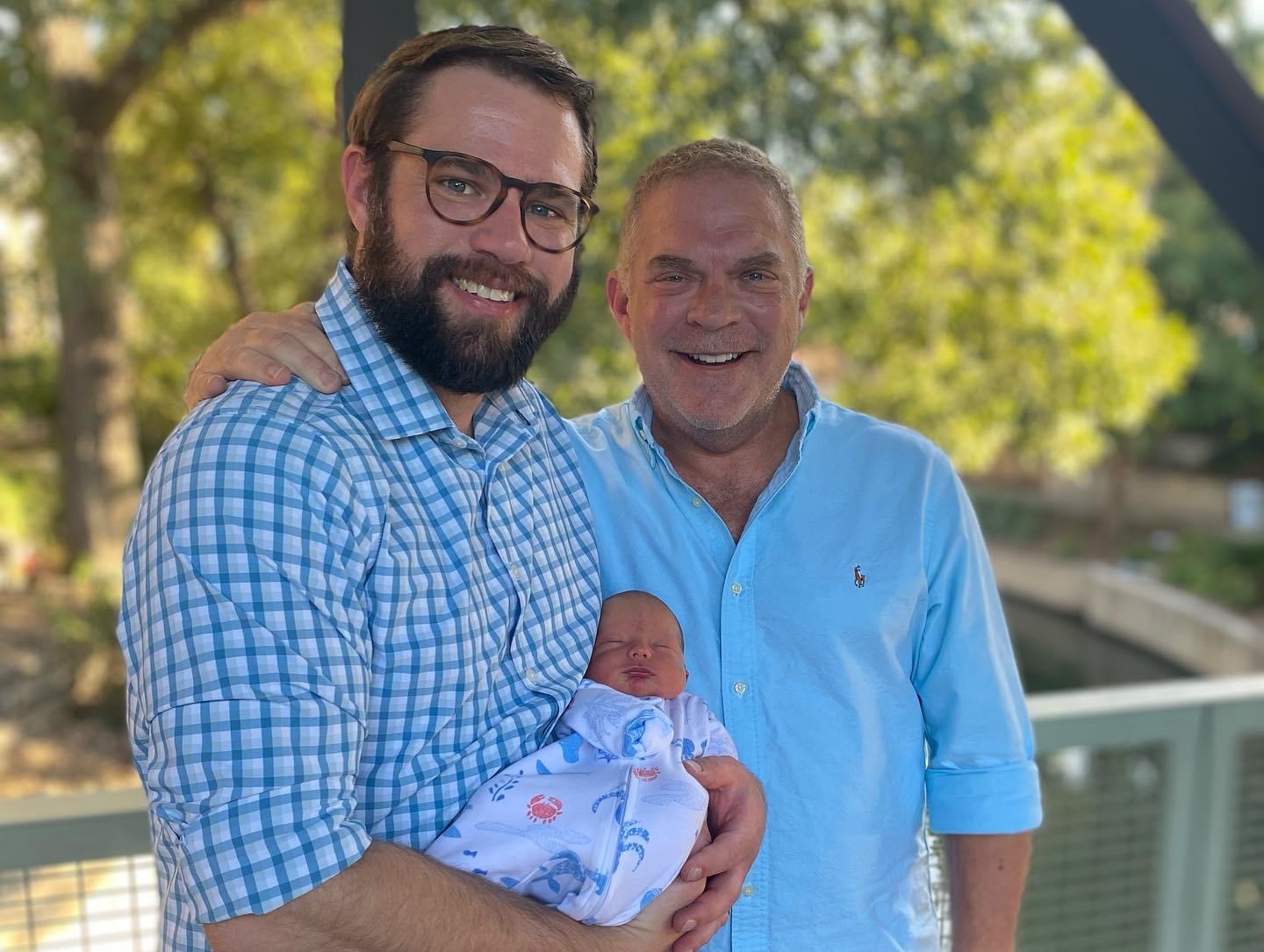 Two gay dads with their newborn baby